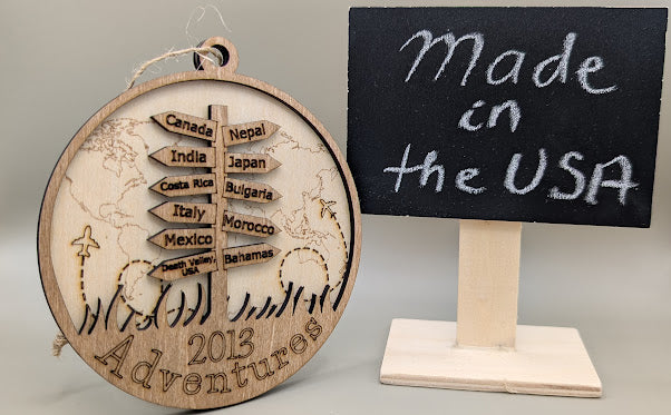 Wooden ornament with world map and travel destinations, next to a sign saying 'Made in the USA'.