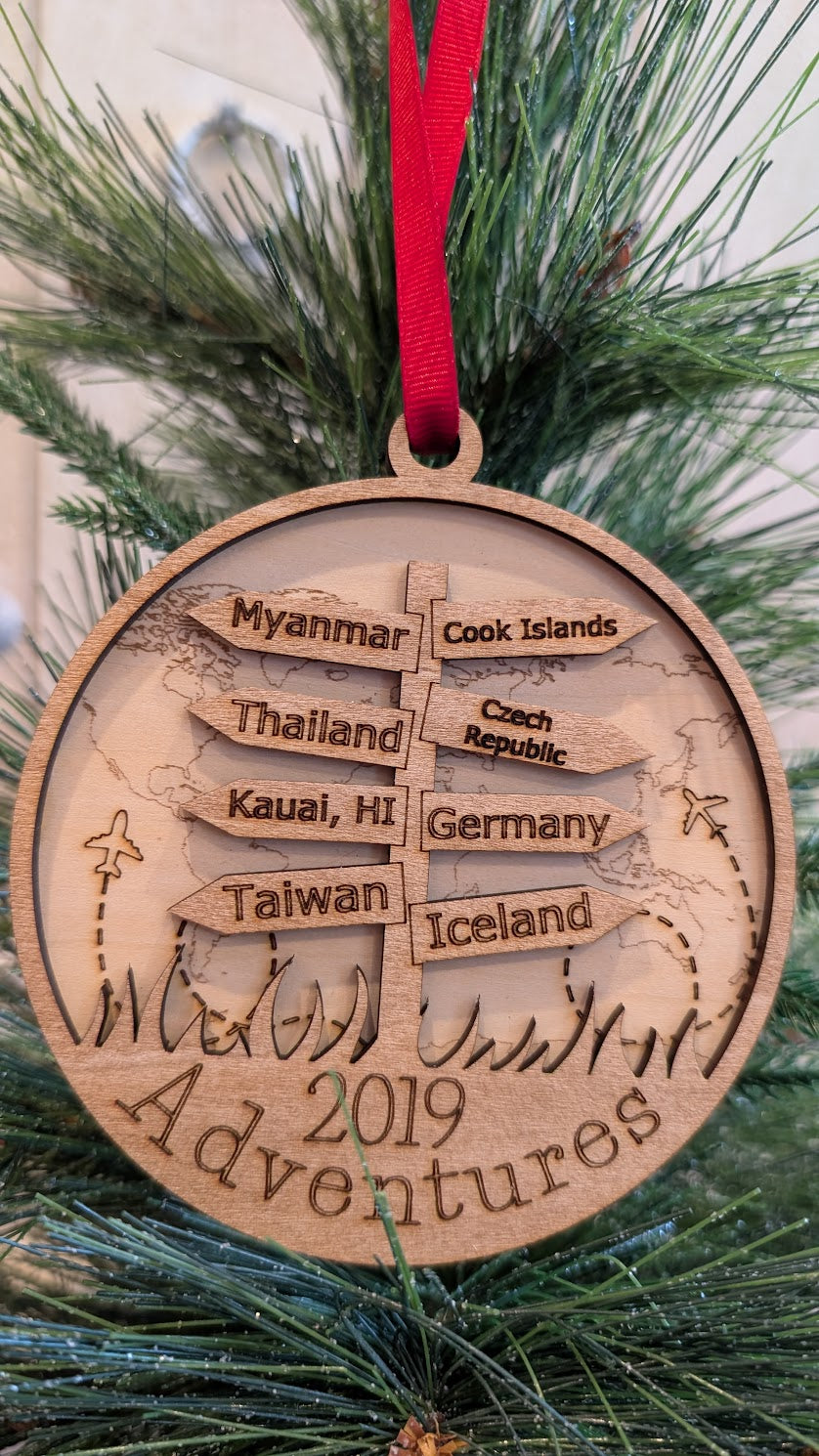 Wooden ornament with engraved destinations on a Christmas tree.