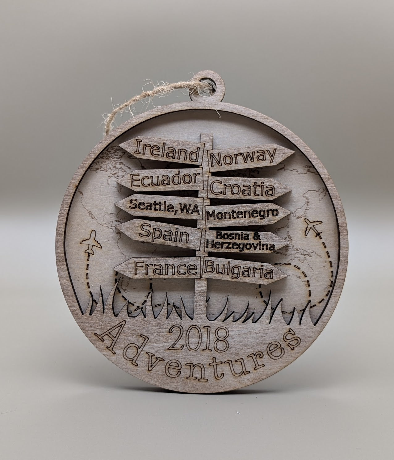 Wooden ornament with engraved travel destinations on a gray background