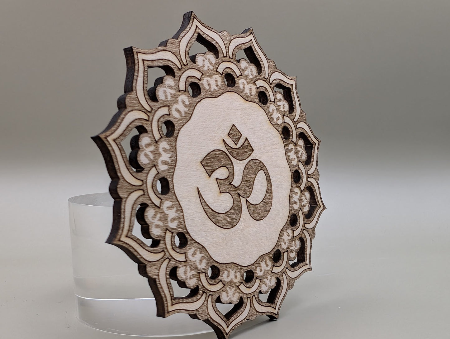 Decorative wooden panel with Om symbol on a gray background