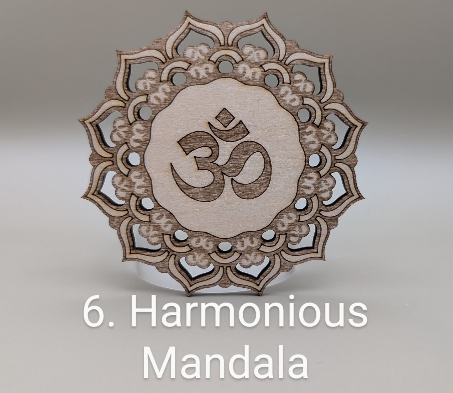 Wooden mandala with Om symbol on a gray background