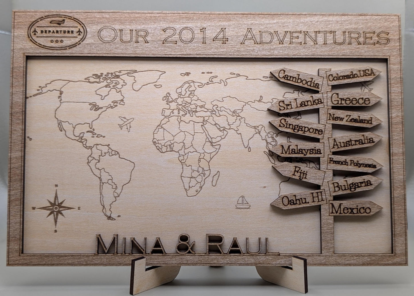 Wooden world map with engraved travel destinations