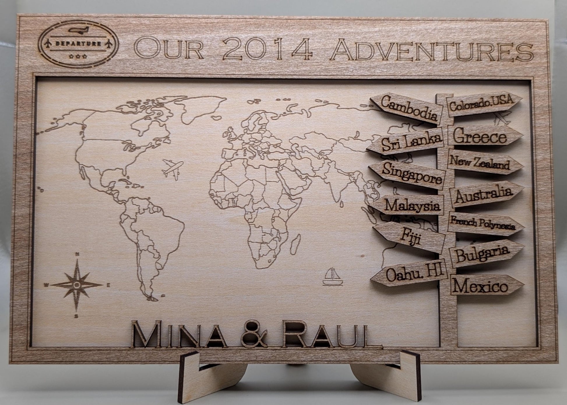 Wooden world map with engraved travel destinations