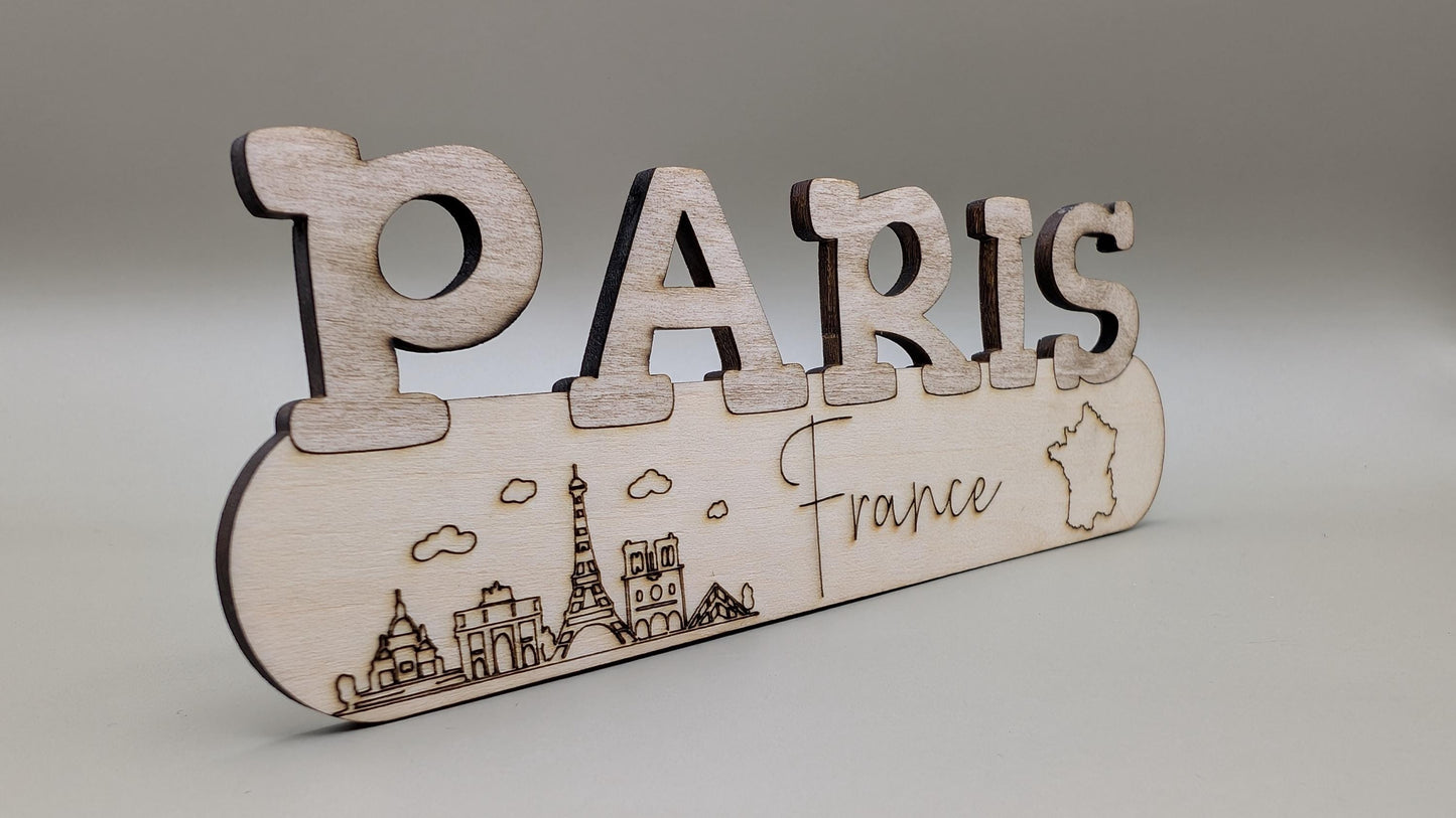 Wooden decorative sign with 'PARIS France' and Eiffel Tower illustration on a gray background