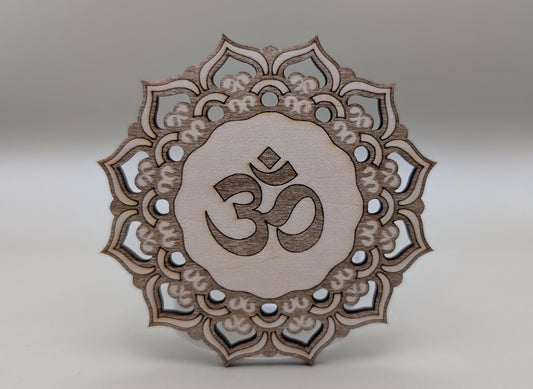 Decorative wooden piece with Om symbol and mandala design on a gray background