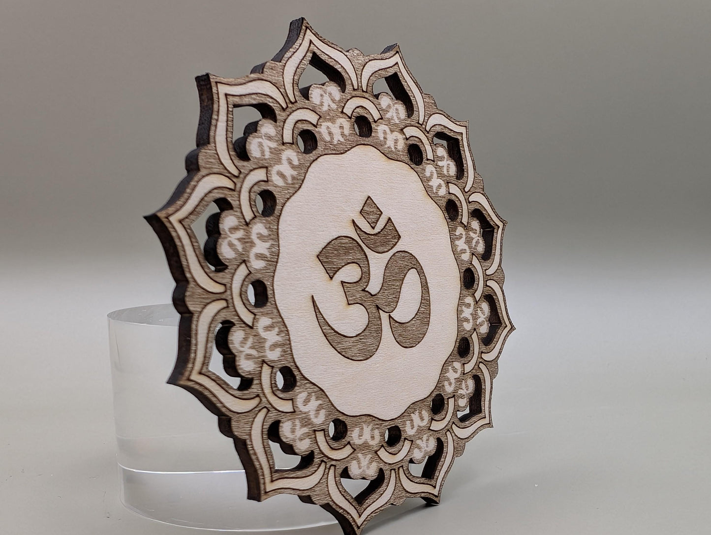 Decorative wooden panel with Om symbol on a gray background