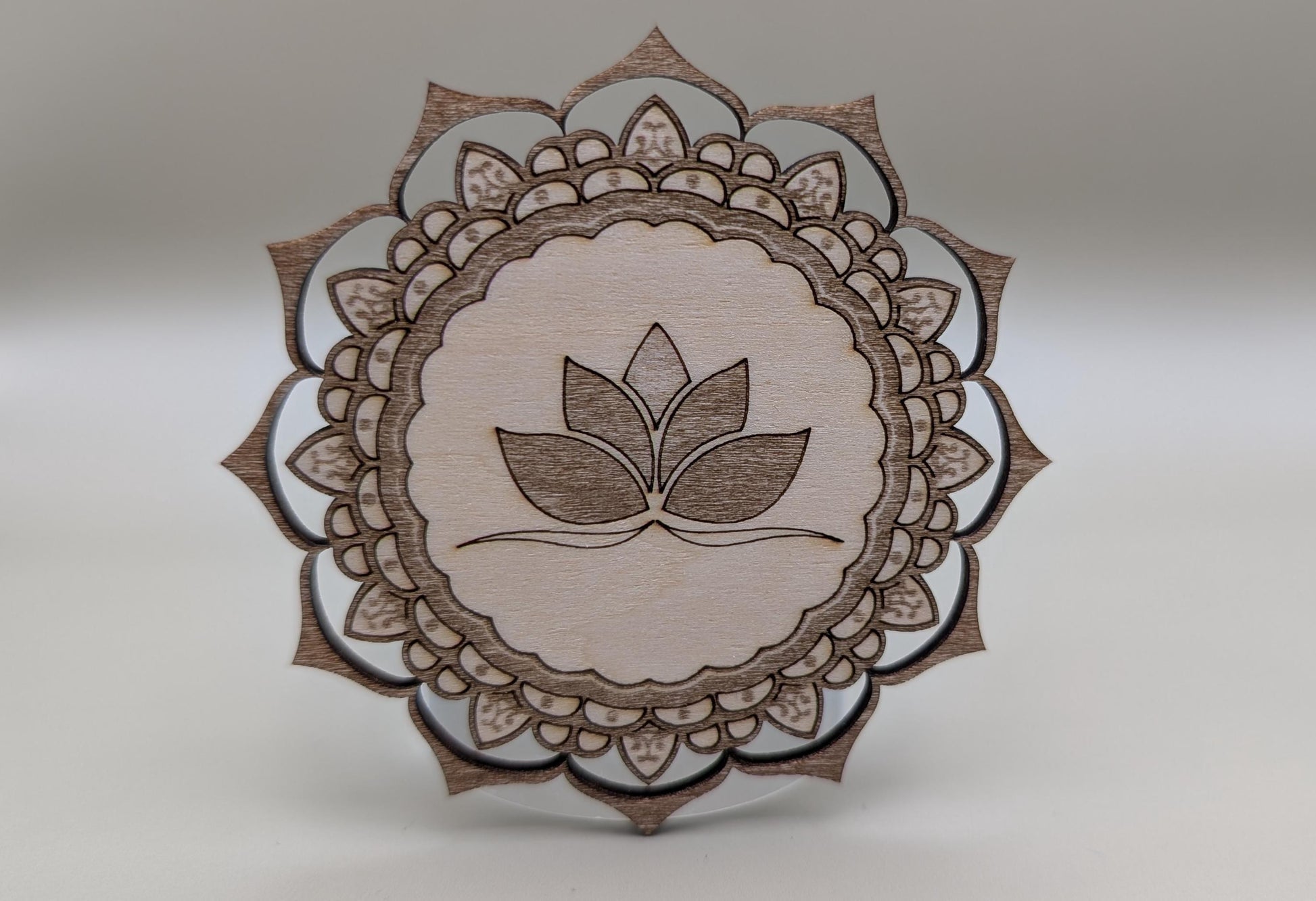 Wooden mandala with leaf design on a gray background