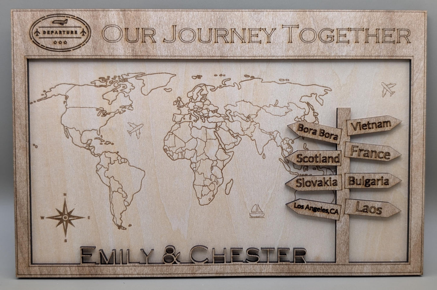 Wooden world map with engraved travel destinations and personalized names 