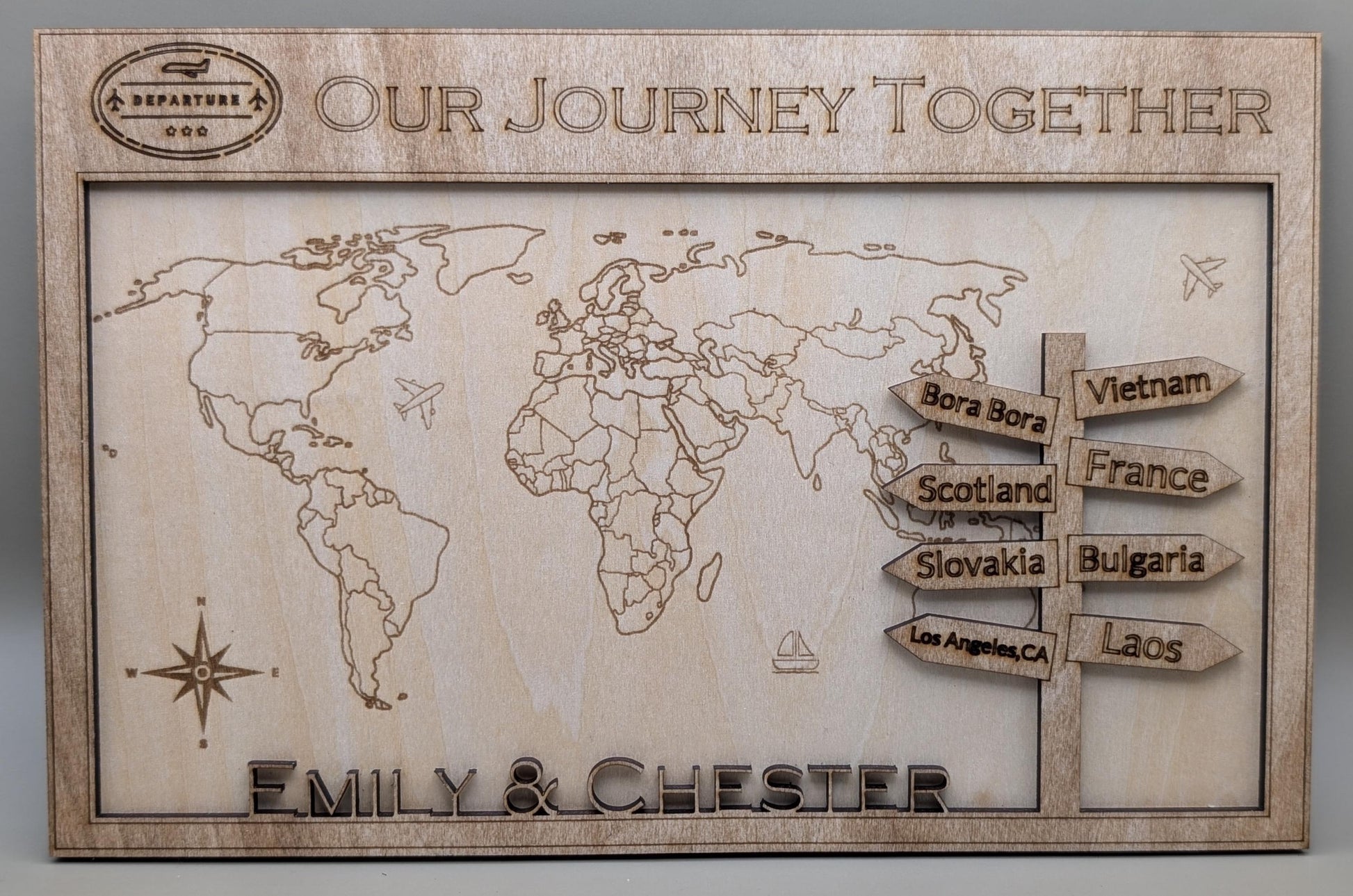 Wooden world map with engraved travel destinations and personalized names 