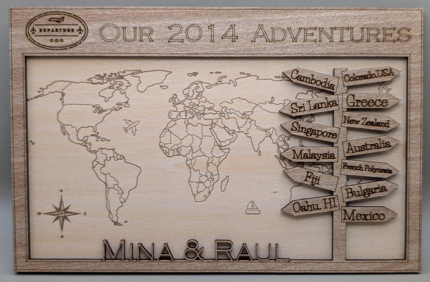 Wooden plaque with world map and travel destinations engraved, featuring personalized names and destinations