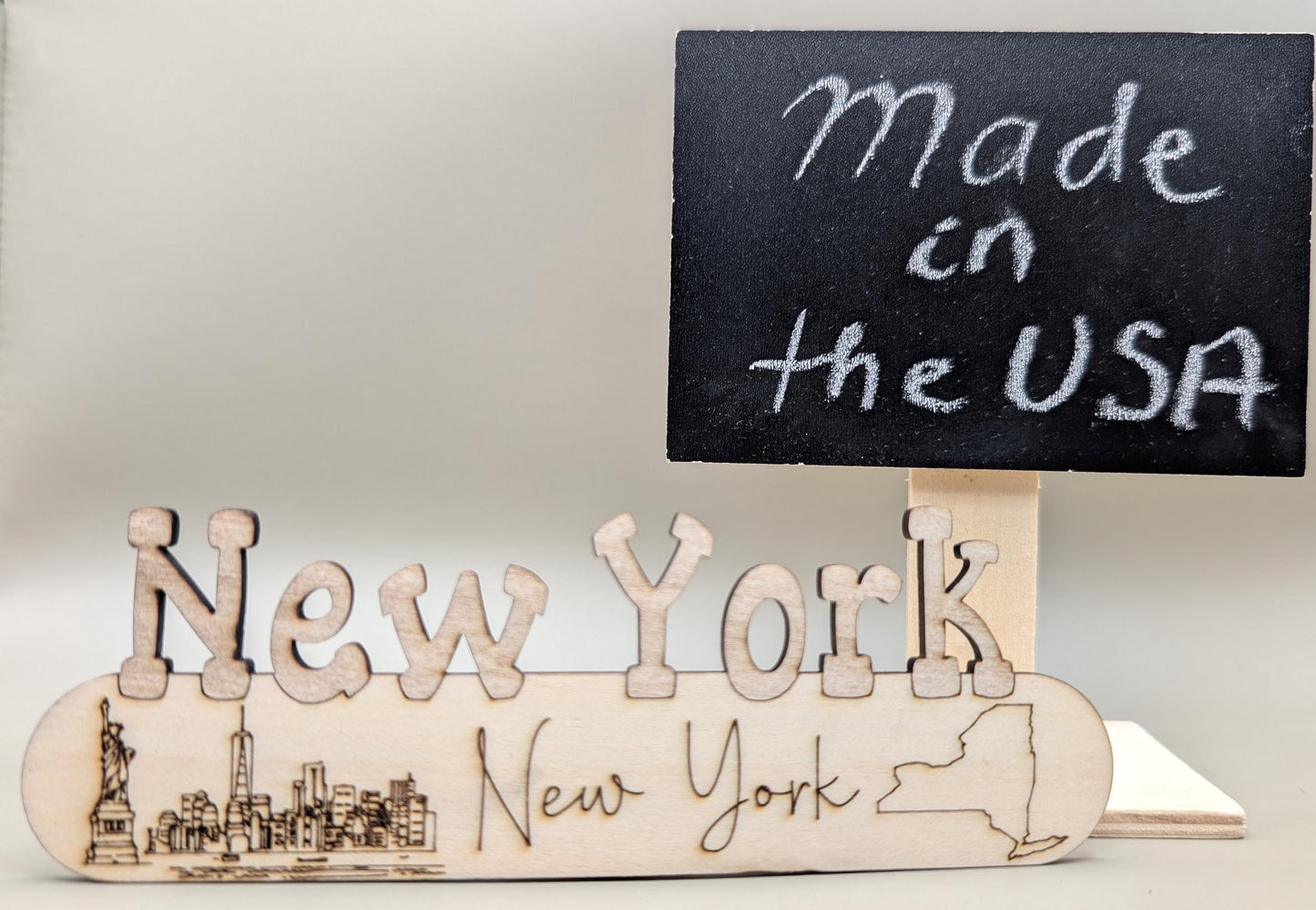 Wooden 'New York' sign with a small blackboard indicating 'Made in the USA'.