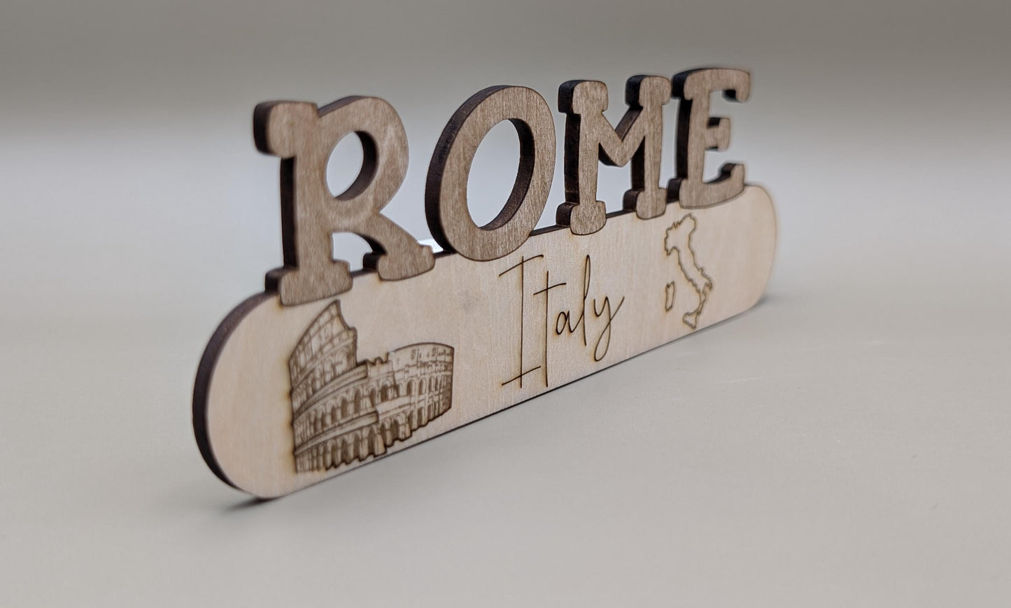 Wooden sign with 'Rome Italy' text and Colosseum illustration on a light gray background