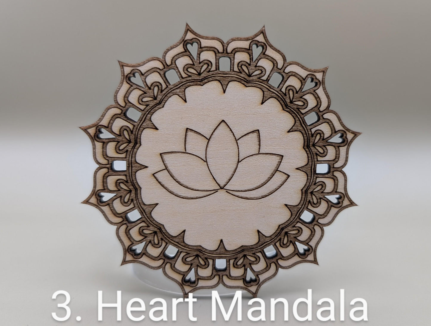 Wooden heart mandala ornament on a light gray background